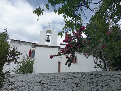 Weie Kirche mit Bougainvilleblten im Vordergrund